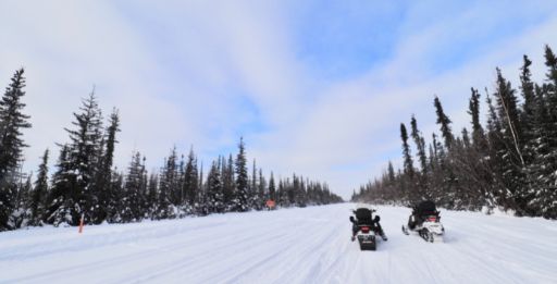 two snow machines on an ice road