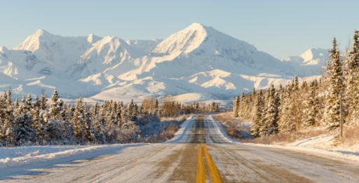 A winter road leading to a mountain